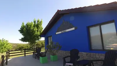 a blue building with chairs and a sign on it at Los Ancares Resort in Mina Clavero