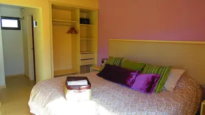 a bedroom with a large bed with pillows at Los Ancares Resort in Mina Clavero