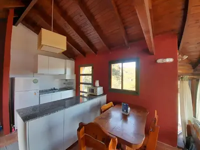a kitchen with a wooden table in a room at Los Ancares Resort in Mina Clavero