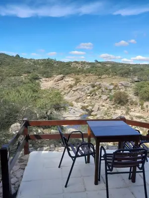 a table and chairs on a balcony with a view of a mountain at Los Ancares Resort in Mina Clavero