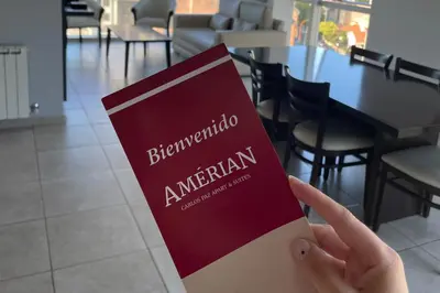 a person holding a book in front of a restaurant at Amérian Carlos Paz in Villa Carlos Paz