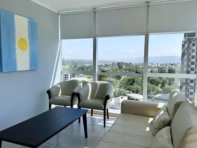 a living room with a couch and chairs and large windows at Amérian Carlos Paz in Villa Carlos Paz