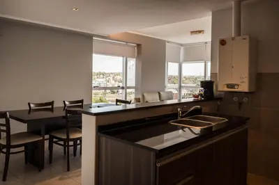 a kitchen with a sink and a table with chairs at Amérian Carlos Paz in Villa Carlos Paz