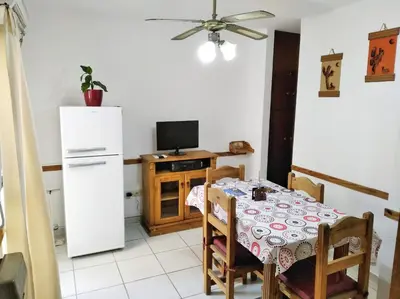 a kitchen with a table and a white refrigerator at M772- Departamento temporal in Cordoba
