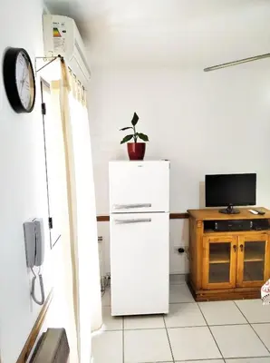 a kitchen with a white refrigerator and a tv at M772- Departamento temporal in Cordoba