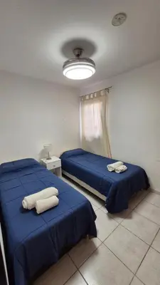 two beds in a room with blue sheets and towels at M772- Departamento temporal in Cordoba