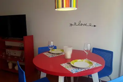 a red table with two glasses and plates on it at Alegre, luminoso y tranquilo en la mejor ubicación in Cordoba