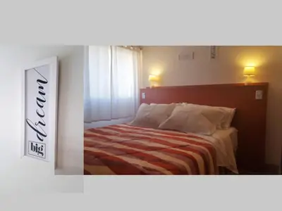 a bedroom with a bed with a striped blanket at Alegre, luminoso y tranquilo en la mejor ubicación in Cordoba