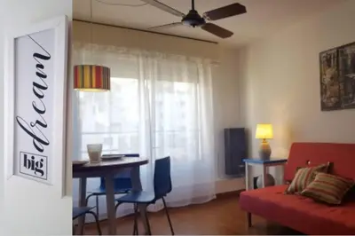 a living room with a red couch and a table and a window at Alegre, luminoso y tranquilo en la mejor ubicación in Cordoba