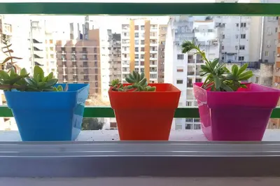 four plants in colorful pots sitting on a window sill at Alegre, luminoso y tranquilo en la mejor ubicación in Cordoba