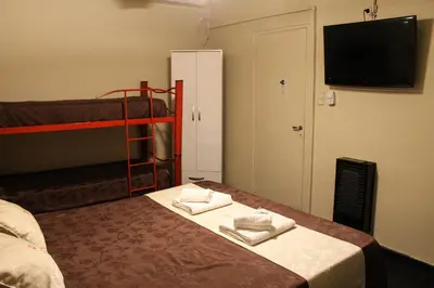a room with a bed and a bunk bed with towels at Casi Guemes Hotel in Cordoba