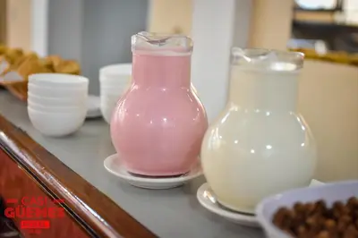 two glass vases sitting on a counter with milk at Casi Guemes Hotel in Cordoba