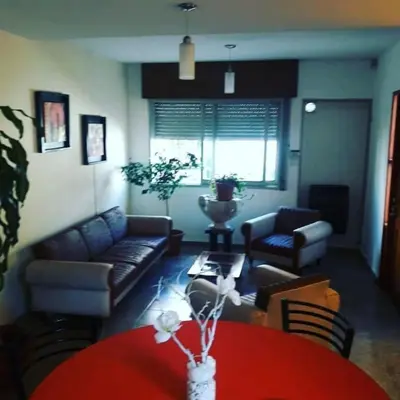 a living room with a couch and a red table at DUPLEX - COCHERA CUBIERTA in Cordoba