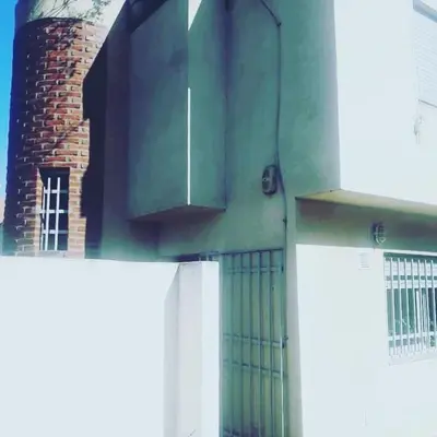 a building with a green door and a brick building at DUPLEX - COCHERA CUBIERTA in Cordoba