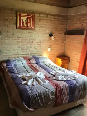a bedroom with a large bed with towels on it at La Soleada casas de campo in Nono