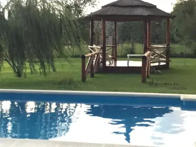 a gazebo next to a swimming pool at La Soleada casas de campo in Nono