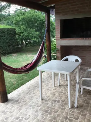 a hammock and a table and chairs on a patio at La Soleada casas de campo in Nono