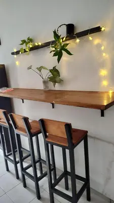 a wooden bar with two stools and a table with lights at HA! 2 Resi para estudiantes in Cordoba