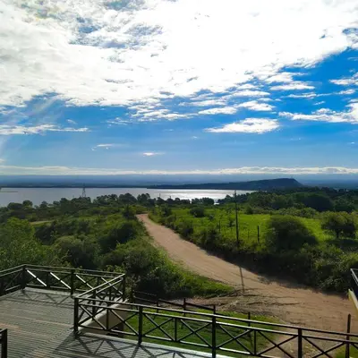 a view of a dirt road next to a body of water at Solar de Roca in Embalse