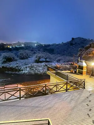 a wooden boardwalk next to a river at night at Solar de Roca in Embalse