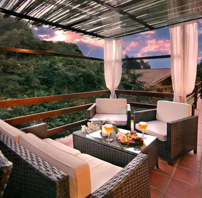 a patio with two chairs and a table with drinks at Terrazas de Belgrano - Club de Montaña in Villa General Belgrano