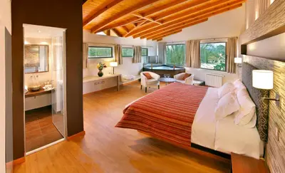 a bedroom with a bed and a living room at Terrazas de Belgrano - Club de Montaña in Villa General Belgrano