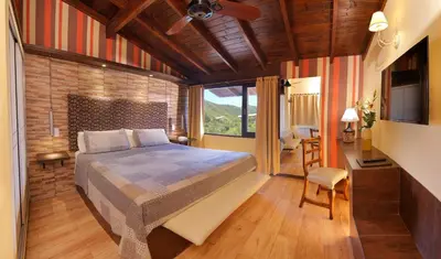a bedroom with a bed and a television in a room at Terrazas de Belgrano - Club de Montaña in Villa General Belgrano