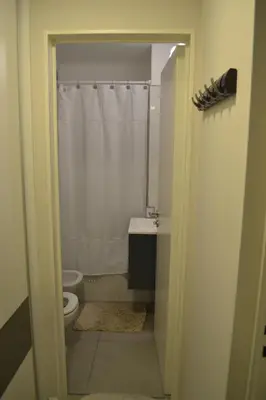 a bathroom with a toilet and a white shower curtain at ESPACIO C Nueva Cordoba in Cordoba