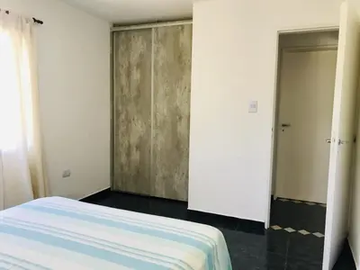 a bedroom with a bed and a closet and a door at Aparts de Montaña Tavullia in Carpintería