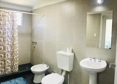 a bathroom with a toilet and a sink and a mirror at Aparts de Montaña Tavullia in Carpintería
