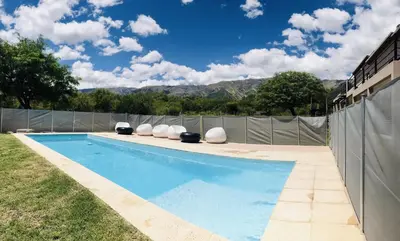 a swimming pool with chairs and a fence at Aparts de Montaña Tavullia in Carpintería