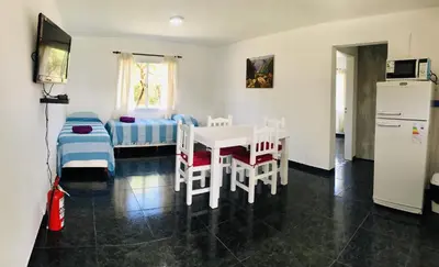 a room with a table and chairs and a bedroom at Aparts de Montaña Tavullia in Carpintería