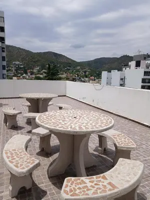a group of tables and benches on a roof at Abuela Chela in Villa Carlos Paz