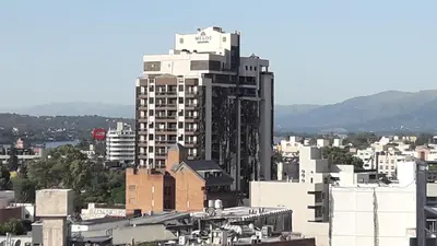 a tall white building in a city with buildings at Abuela Chela in Villa Carlos Paz