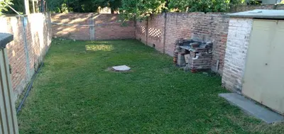 a yard with a fence and a brick wall at Dpto Low Cost temporada 2026 in Mina Clavero