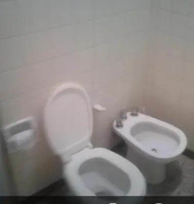 a bathroom with a white toilet and a sink at Dpto Low Cost temporada 2026 in Mina Clavero