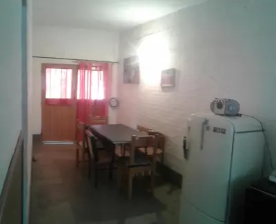 a dining room with a table and a refrigerator at Dpto Low Cost temporada 2026 in Mina Clavero
