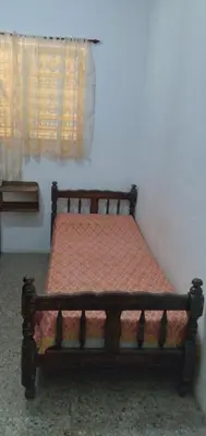 a wooden bed in a room with a window at Dpto Low Cost temporada 2026 in Mina Clavero