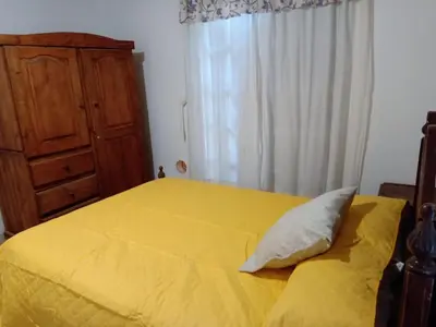 a yellow bed with a pillow on top of it at Complejo Los Sauces in Mina Clavero