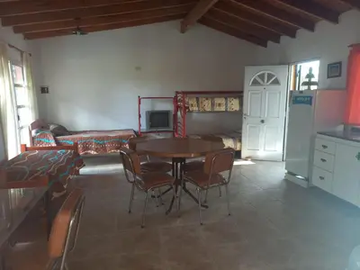a living room with a table and chairs and a couch at Complejo Los Sauces in Mina Clavero