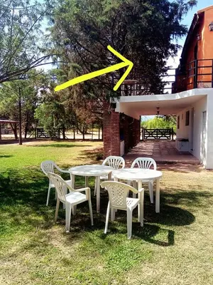 a group of tables and chairs with a x on it at Complejo Los Sauces in Mina Clavero