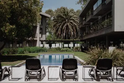 a group of chairs sitting next to a swimming pool at La Urumpta Hotel, AKEN MIND in Río Cuarto