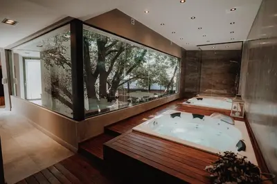 a large bathroom with a hot tub and a large window at La Urumpta Hotel, AKEN MIND in Río Cuarto
