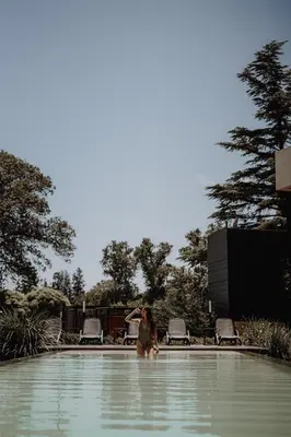 a woman standing in the water in a swimming pool at La Urumpta Hotel, AKEN MIND in Río Cuarto