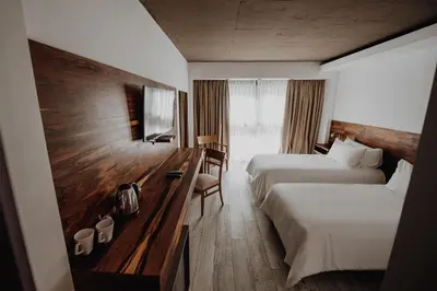 a hotel room with two beds and a desk at La Urumpta Hotel, AKEN MIND in Río Cuarto