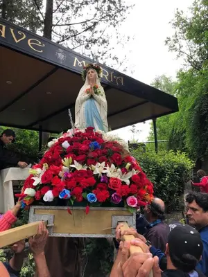 a statue of a woman sitting on a pile of flowers at Saint Michel Departamentos para turismo in Alta Gracia