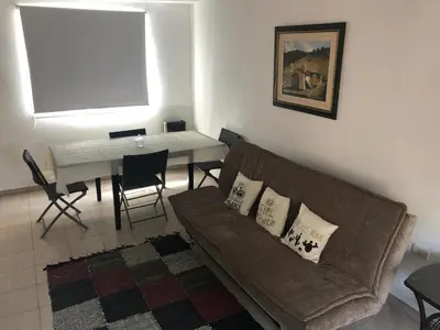 a living room with a couch and a table at Saint Michel Departamentos para turismo in Alta Gracia
