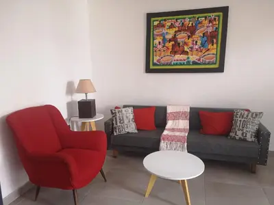a living room with a couch and a chair and a table at Departamento Ripozi Centro muy luminoso in Cordoba