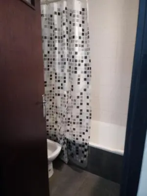 a bathroom with a shower curtain and a toilet at Departamento Ripozi Centro muy luminoso in Cordoba