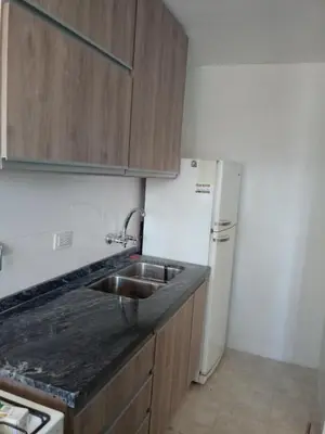 a kitchen with a sink and a white refrigerator at Departamento Ripozi Centro muy luminoso in Cordoba